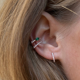 gold piercing with diamonds and emeralds jardin de aire