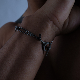 Silver bracelet with an accent link and a cross