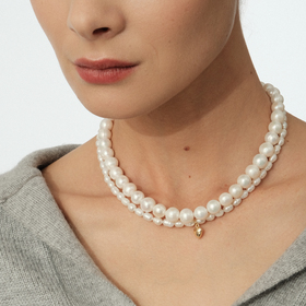 Necklace made of natural pearls with a golden heart pendant