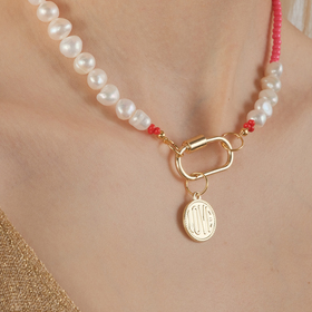pink beads and pearls necklace with a carabiner and a coin